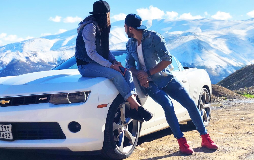 Två personer utanför en vit bil